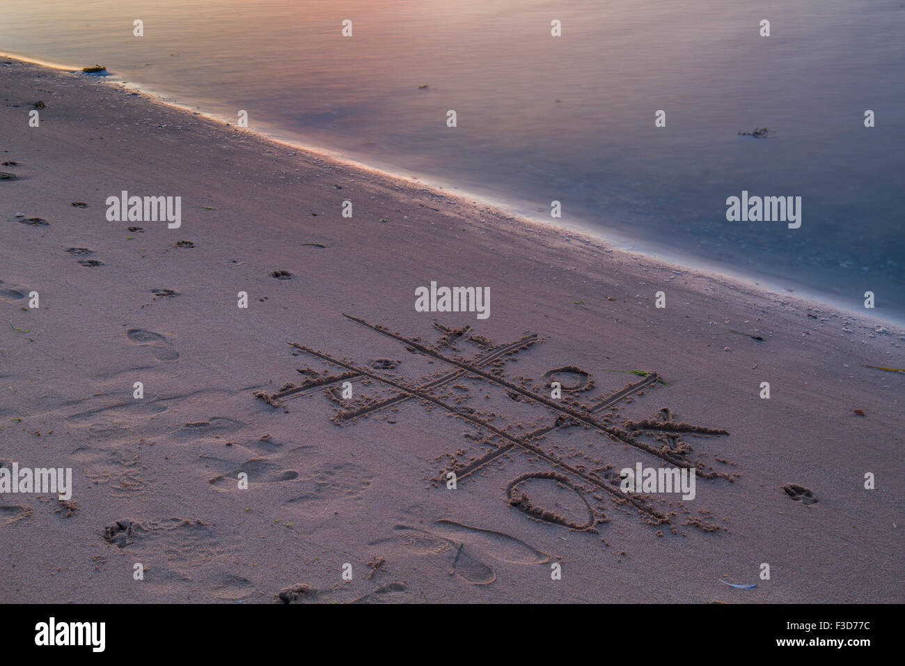 Coucher du soleil divertissement dessin dans le sable Banque D'Images