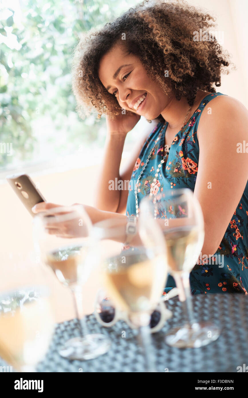 Young woman using smart phone at restaurant Banque D'Images