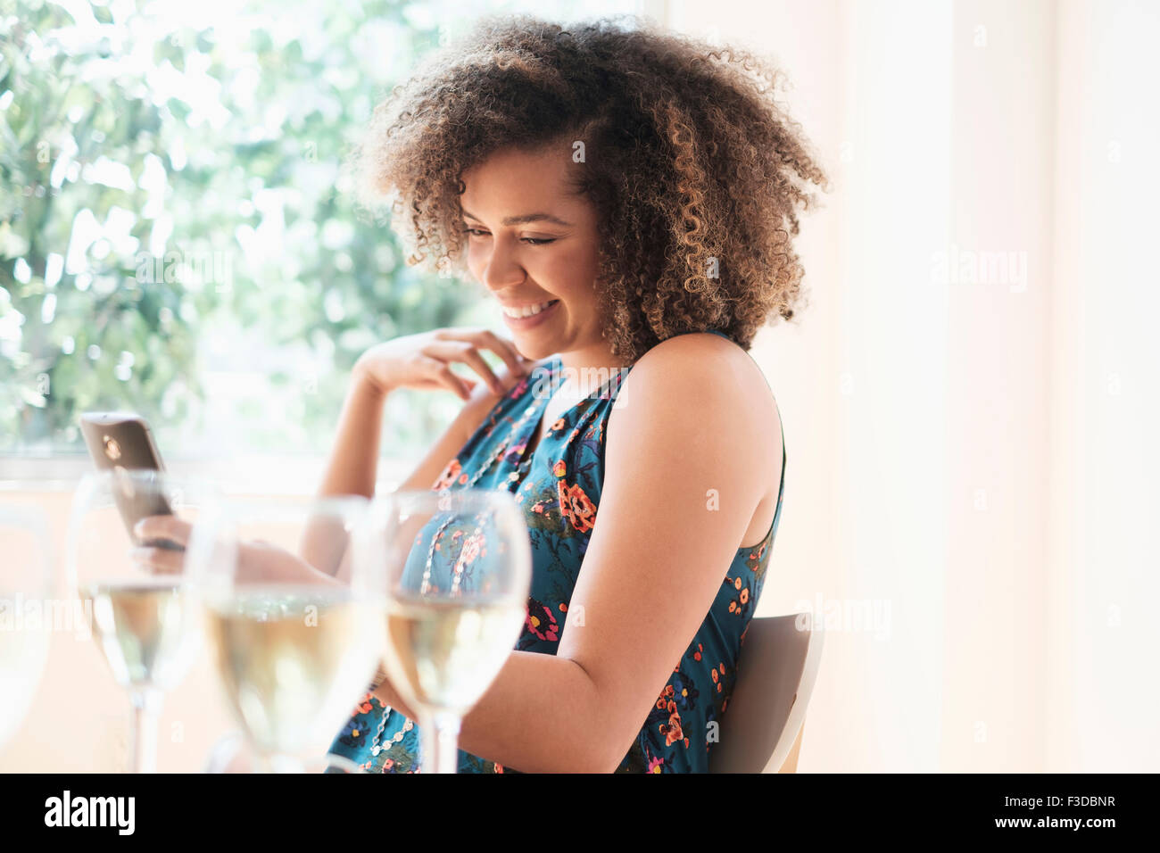 Young woman using smart phone at restaurant Banque D'Images