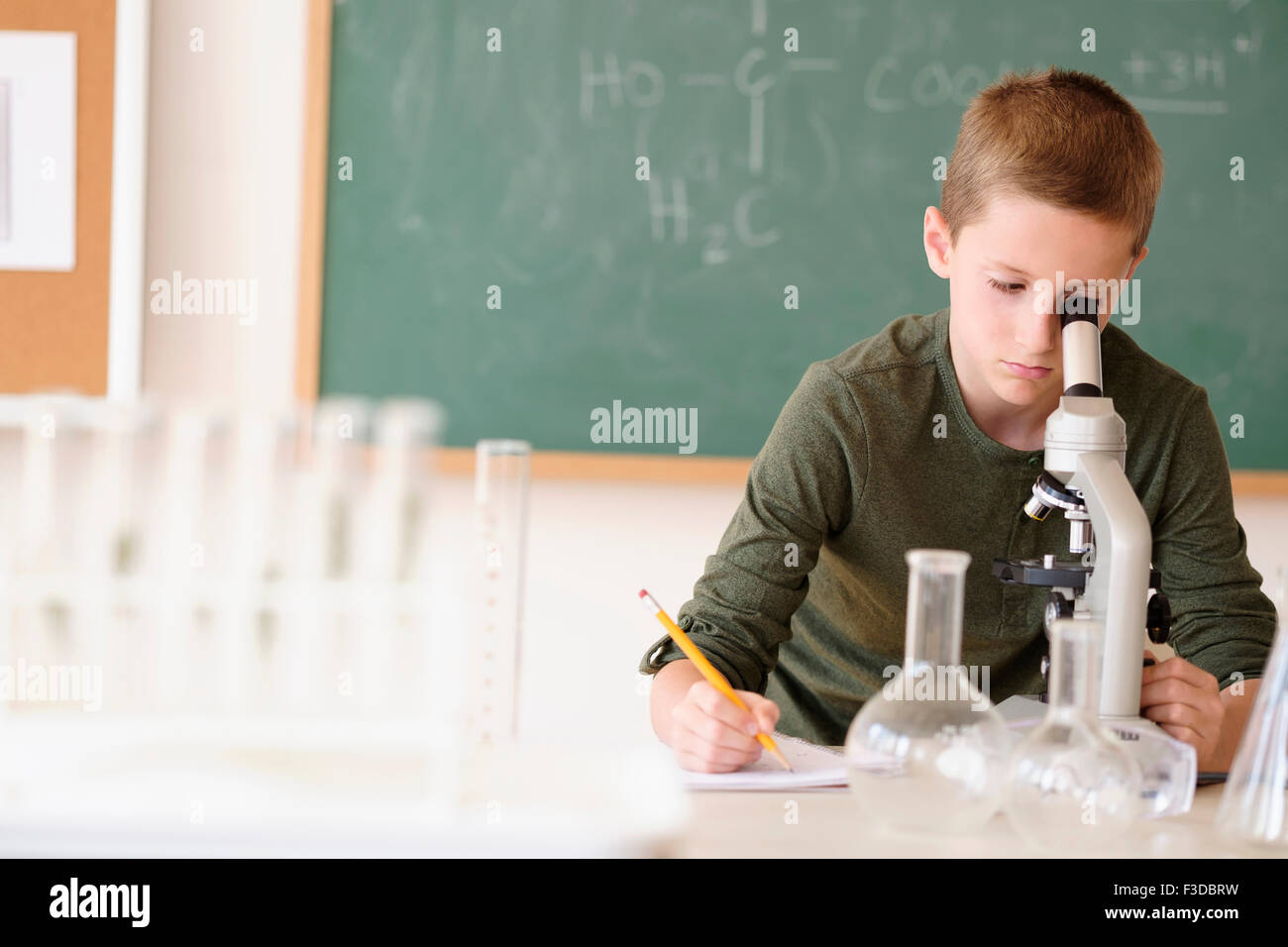 Boy (8-9) à la loupe à travers Banque D'Images