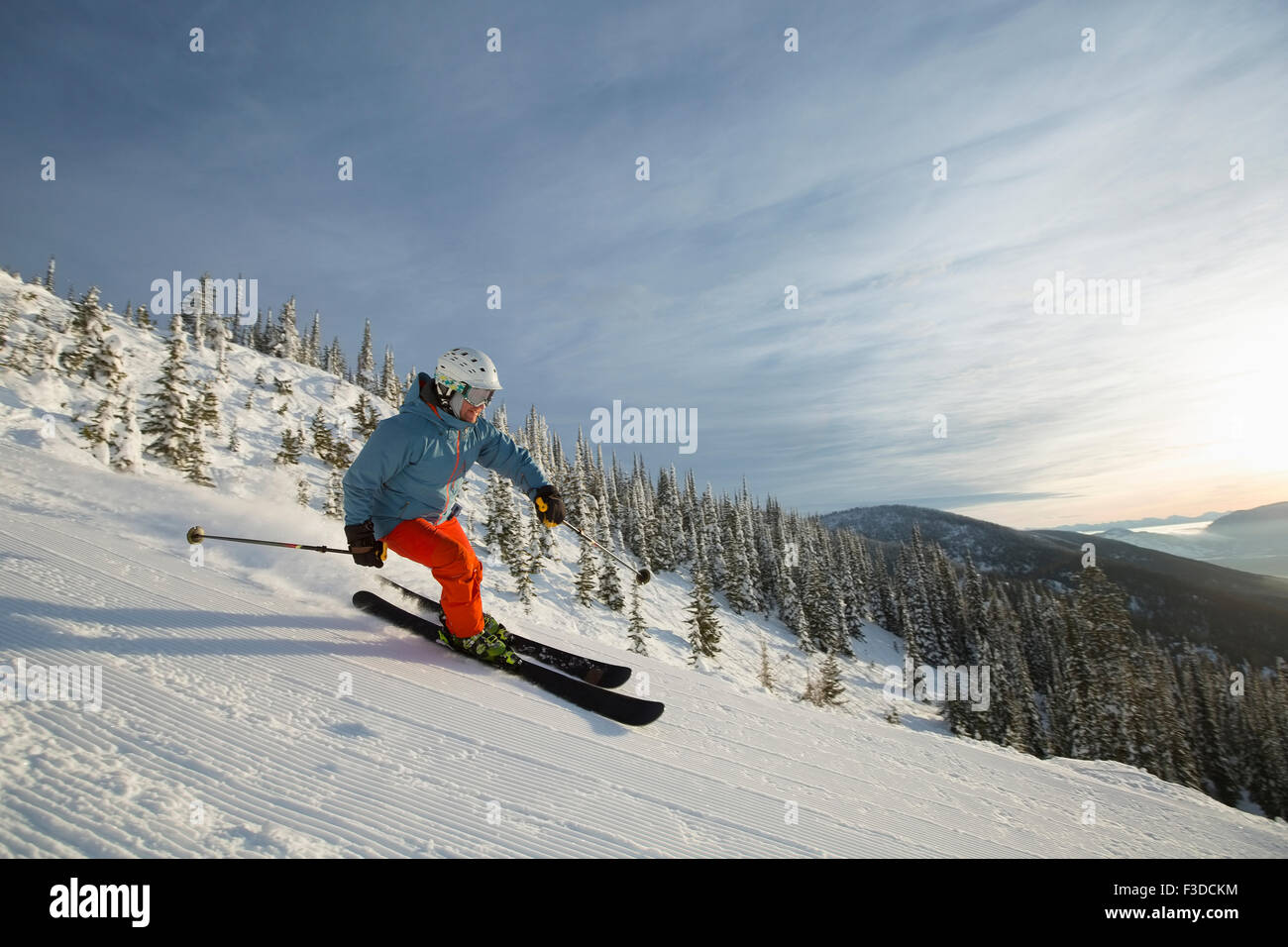 Homme mûr sur la pente de ski au coucher du soleil Banque D'Images
