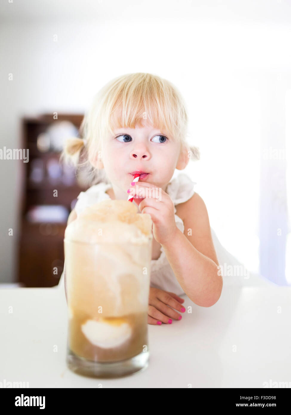 Girl (2-3) drinking milk-shake Banque D'Images