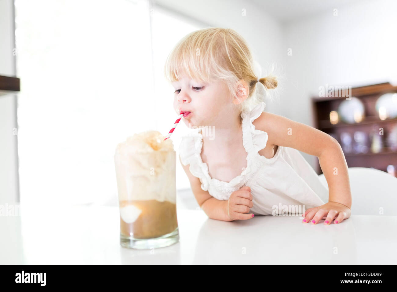 Girl (2-3) drinking milk-shake Banque D'Images