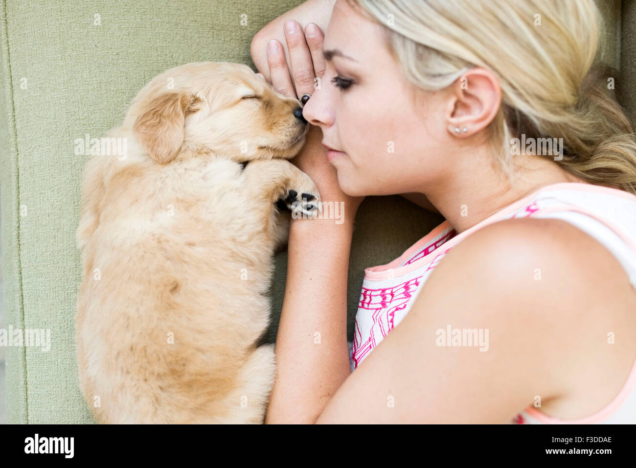Portrait de chiot avec propriétaire allongé sur canapé Banque D'Images