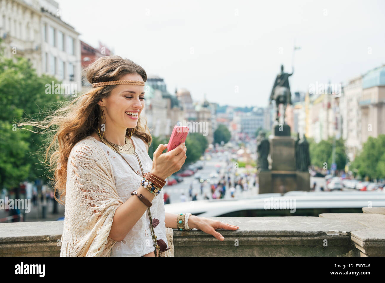 Heureux hippie mode touriste avec un téléphone mobile sur la place Venceslas à Prague. Dans l'arrière-plan statue de Saint Venceslas à P Banque D'Images