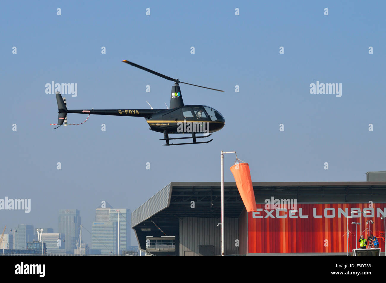 Robinson R44 G-FRYA exploité par A2B Aero Limited arrive sur terre au London's Excel Exhibition Centre à participer à salon Helitech Banque D'Images