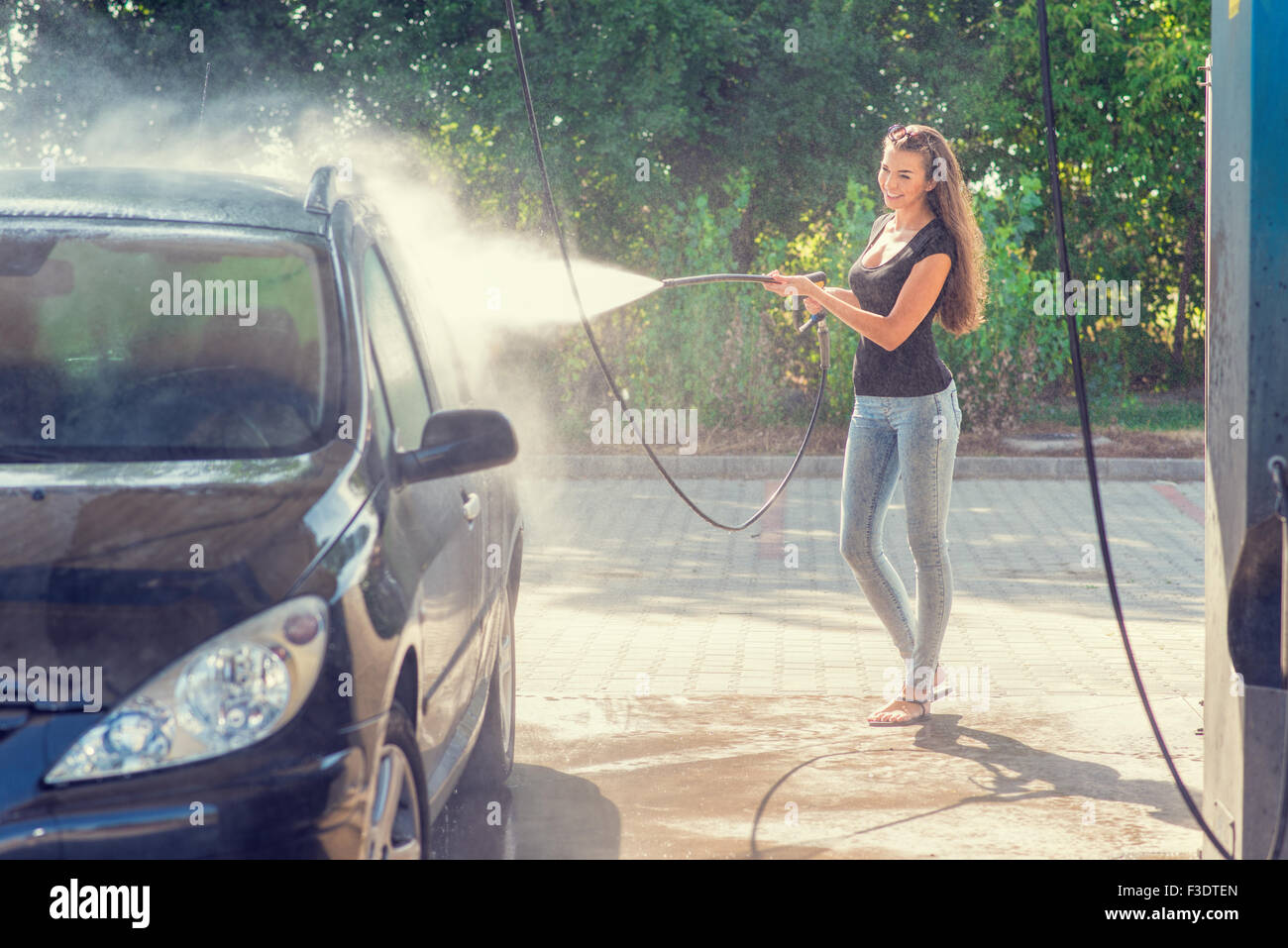Jolie femme dans le lavage de voiture - lavage à la main Banque D'Images