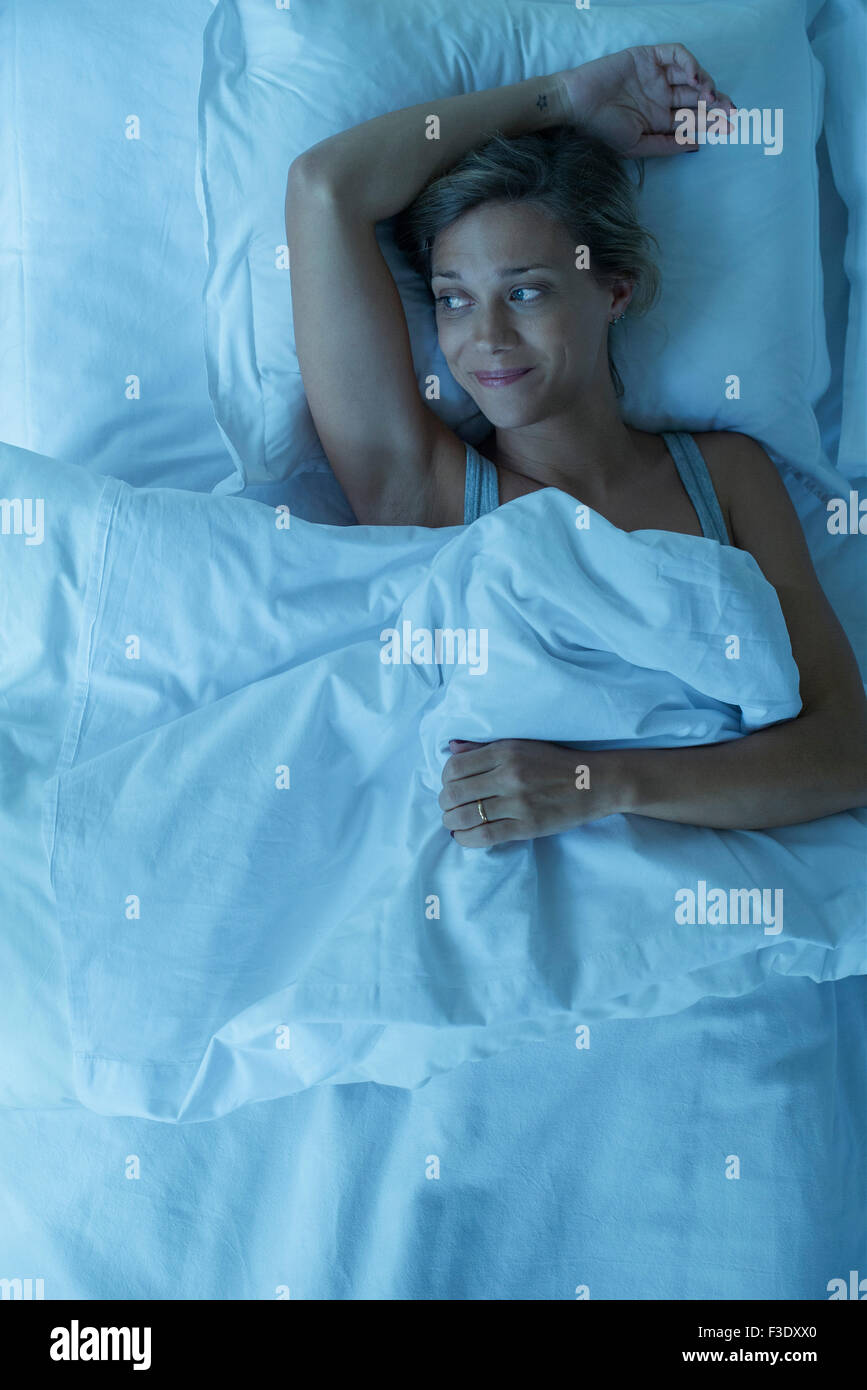 Woman Lying in Bed, smiling Banque D'Images