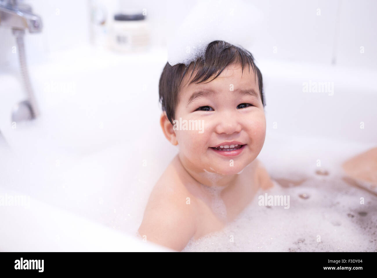 Baby Boy bénéficiant d''un bain à bulles, portrait Banque D'Images