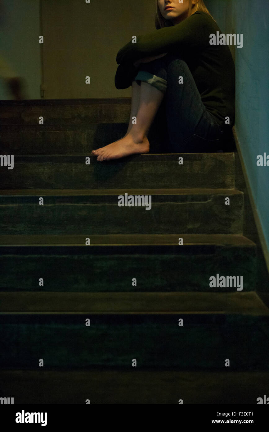 Femme assise seule dans l'escalier Banque D'Images