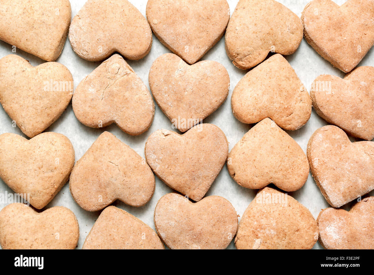 Les cookies en forme de cœur sur papier cuisson Banque D'Images