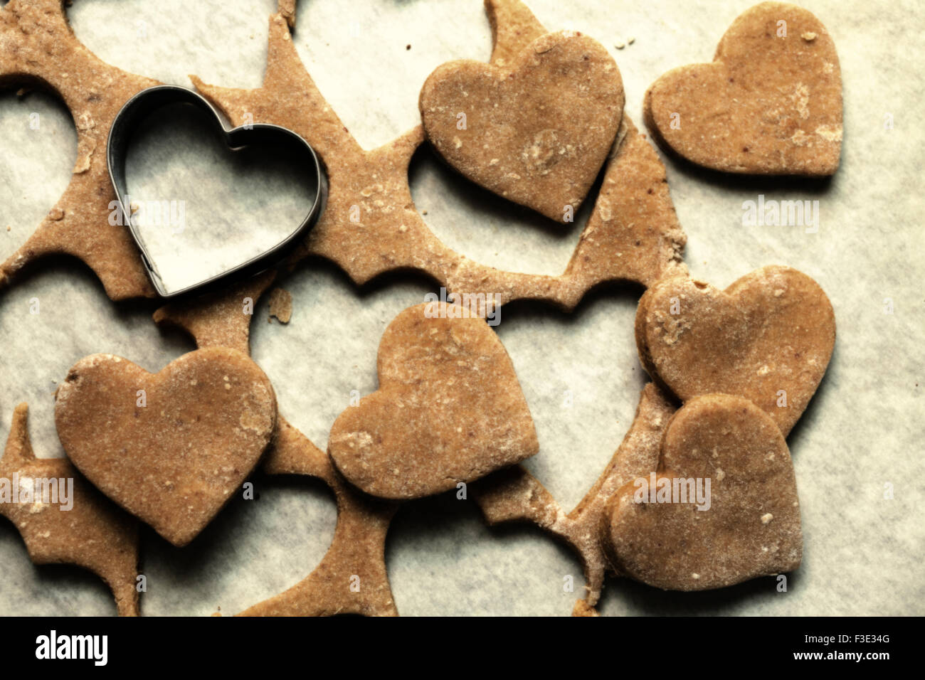 Les cookies en forme de cœur sur papier cuisson Banque D'Images
