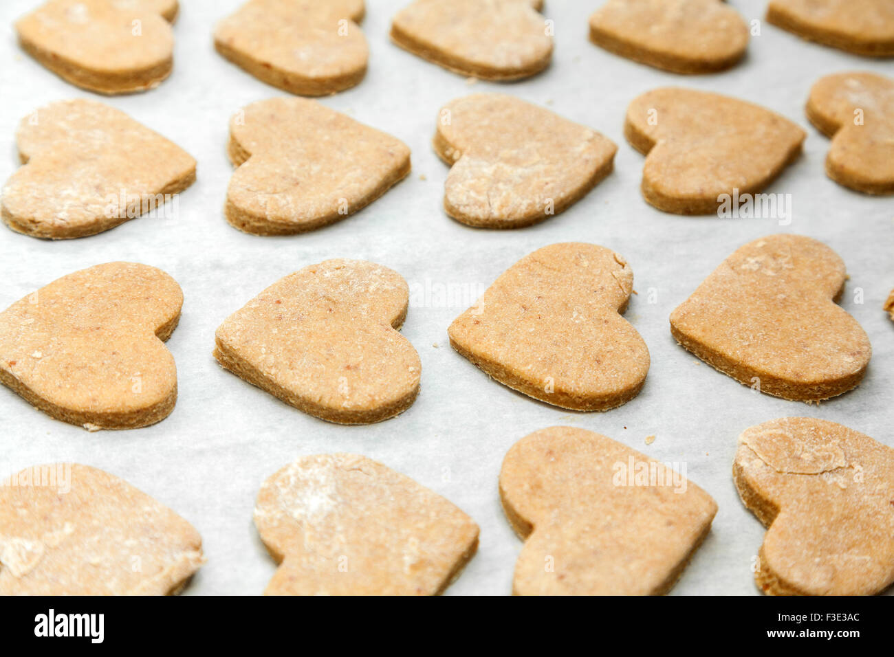 Les cookies en forme de cœur sur papier cuisson Banque D'Images