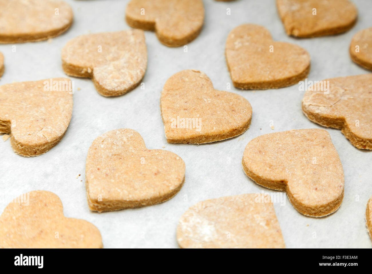 Les cookies en forme de cœur sur papier cuisson Banque D'Images