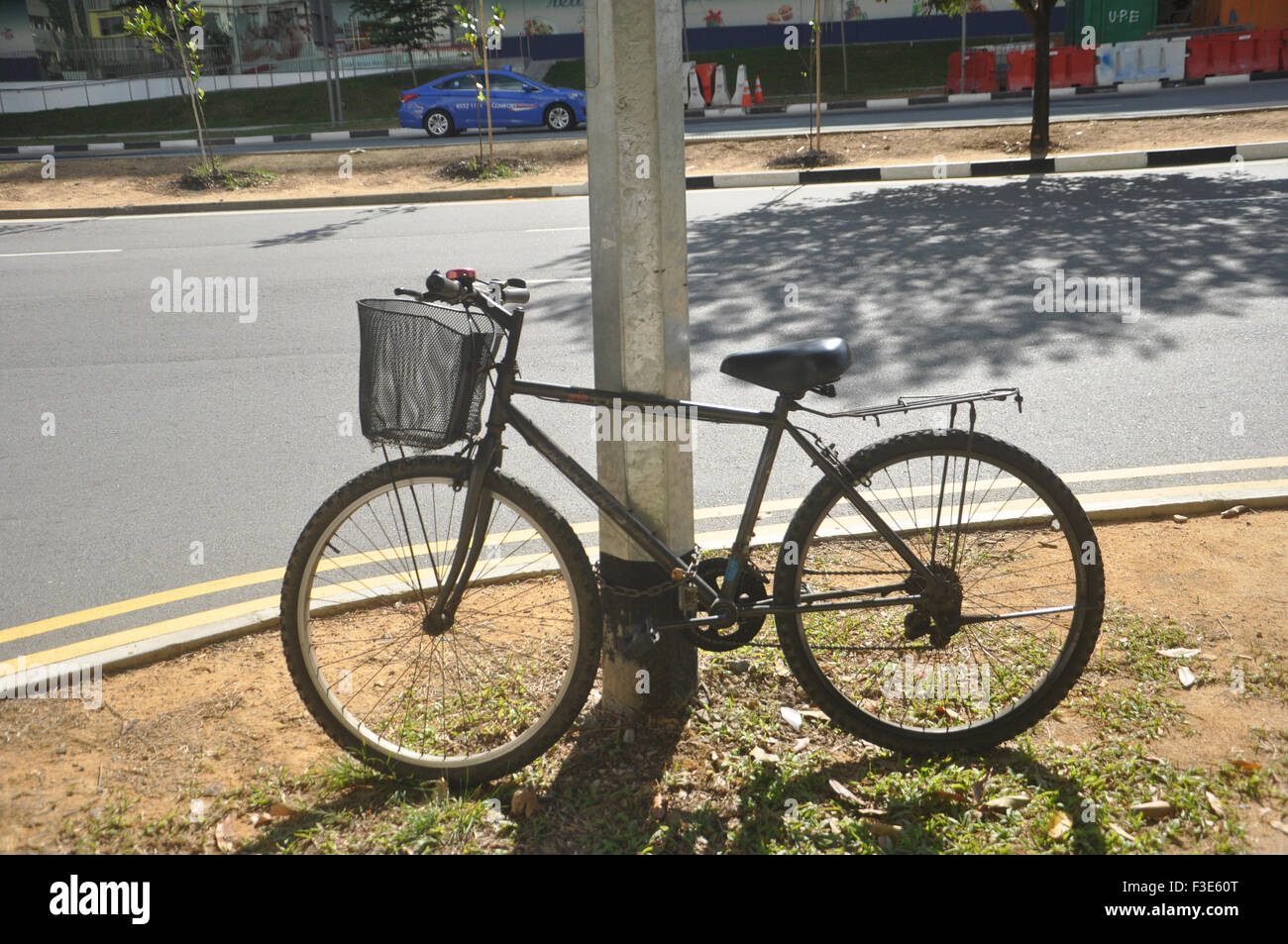 Un vélo attaché sur un poteau électrique à Kallang Road, Singapour. Banque D'Images