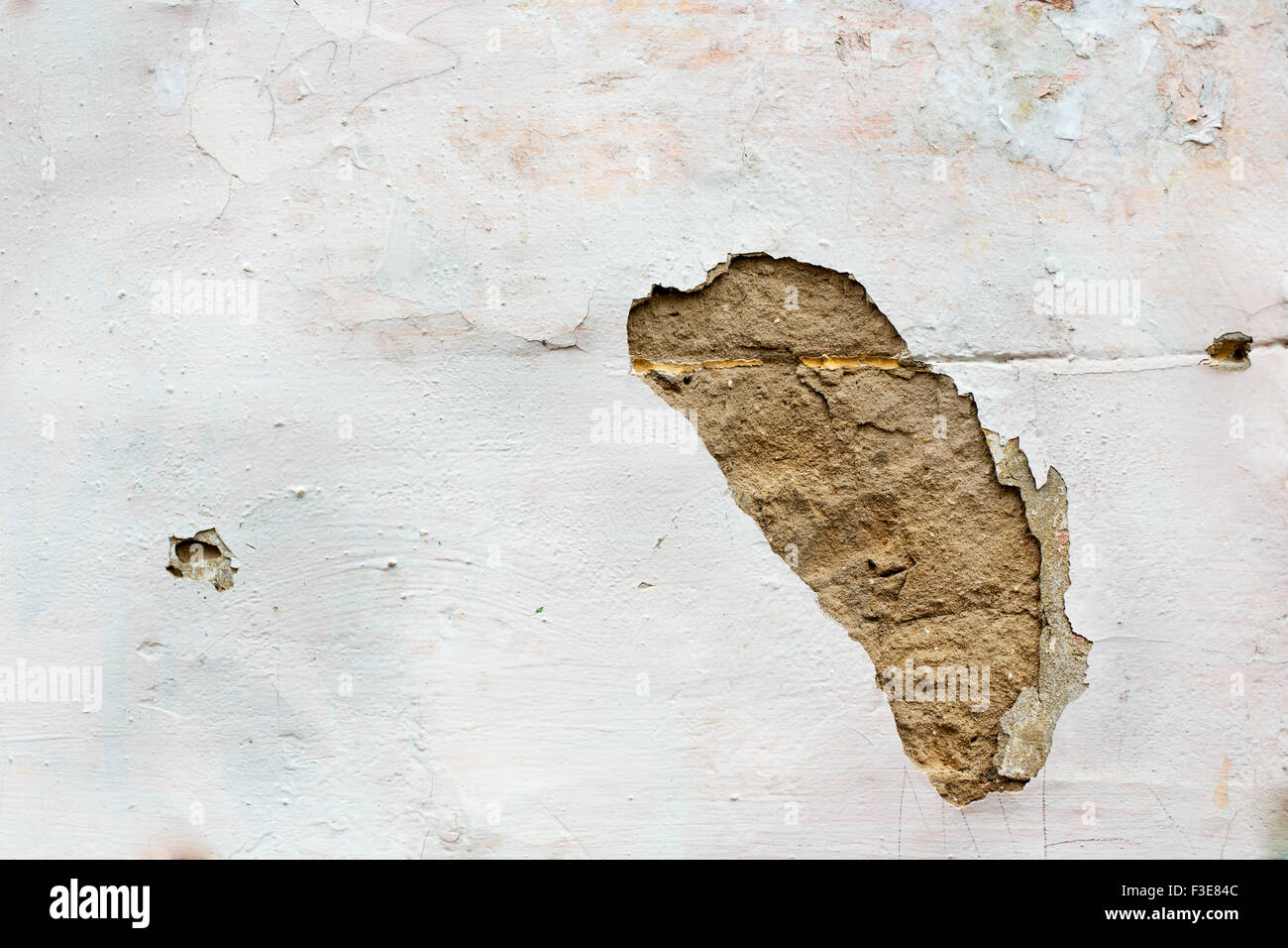 Trou dans le plâtre du mur blanc Banque D'Images