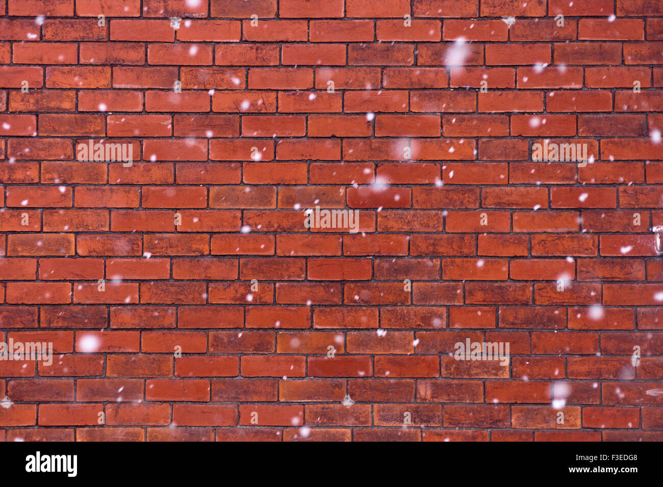 Mur de brique rouge avec des flocons tomber en face d'elle. Banque D'Images