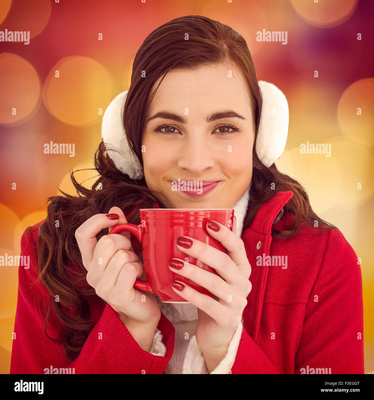 Image composite de femme dans des vêtements d'hiver bénéficiant d'une boisson chaude Banque D'Images