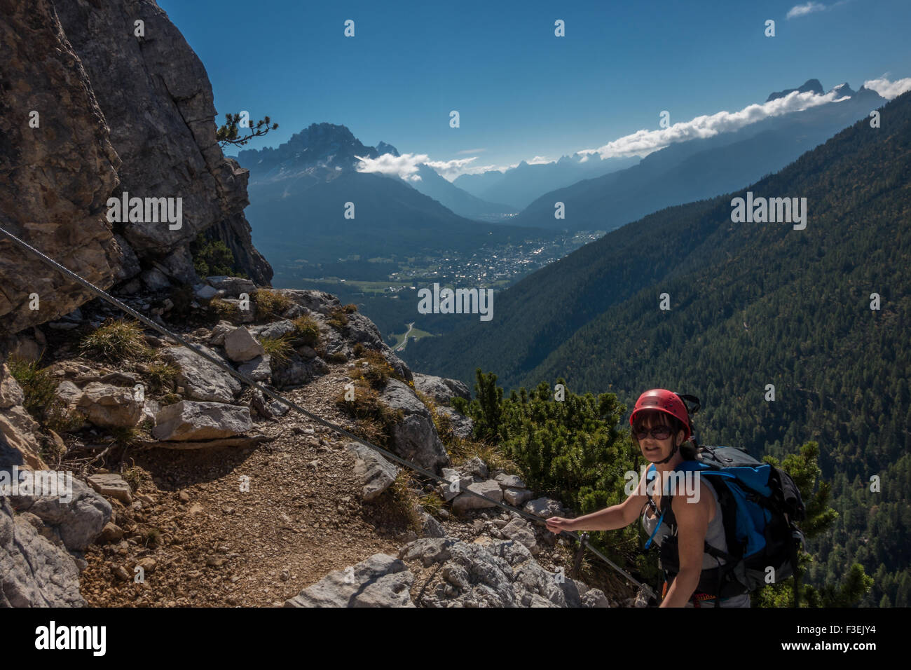 Grimpeur femelle personne presque une vire sur l'Ettore Bovero via ferrata avec vue sur Cortina (Dolomites, Italie) Banque D'Images