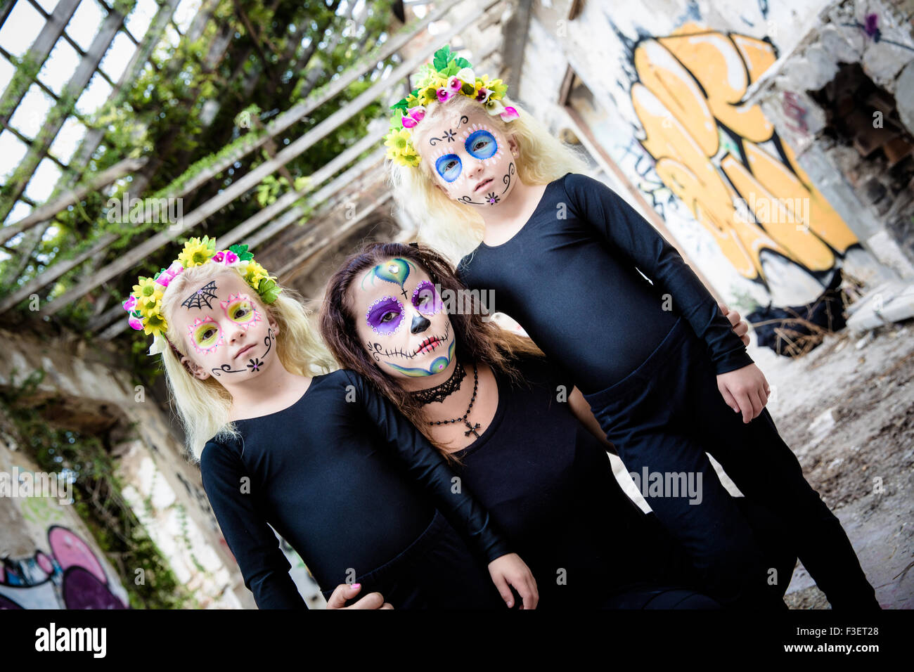 Femme et deux sœurs jumelles avec crâne en sucre makeup in maison abandonnée Banque D'Images
