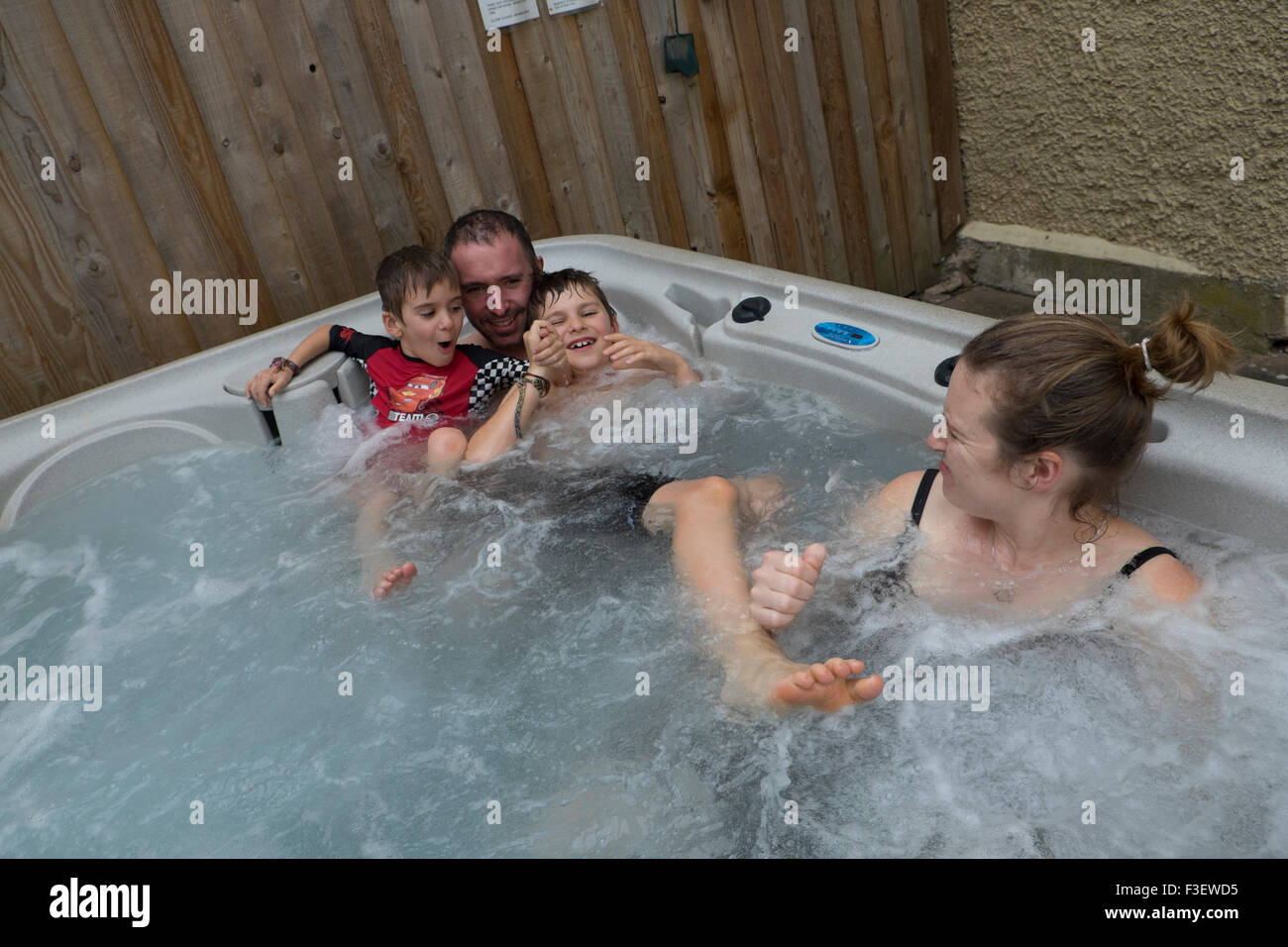 Détente en famille dans l'eau chaude à remous, Herefordshire, Angleterre, RU Banque D'Images