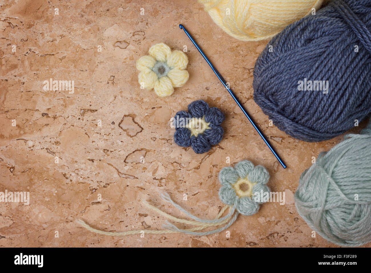 Colorés à la main de fleurs au crochet avec pelote sur table de marbre. Focus sélectif. Copy space Banque D'Images
