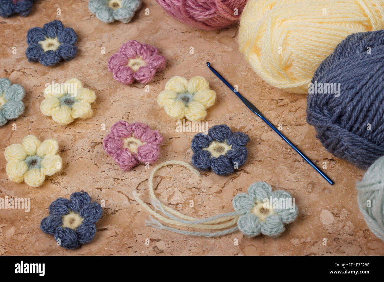 Colorés à la main de fleurs au crochet avec pelote sur table de marbre. Selective focus Banque D'Images