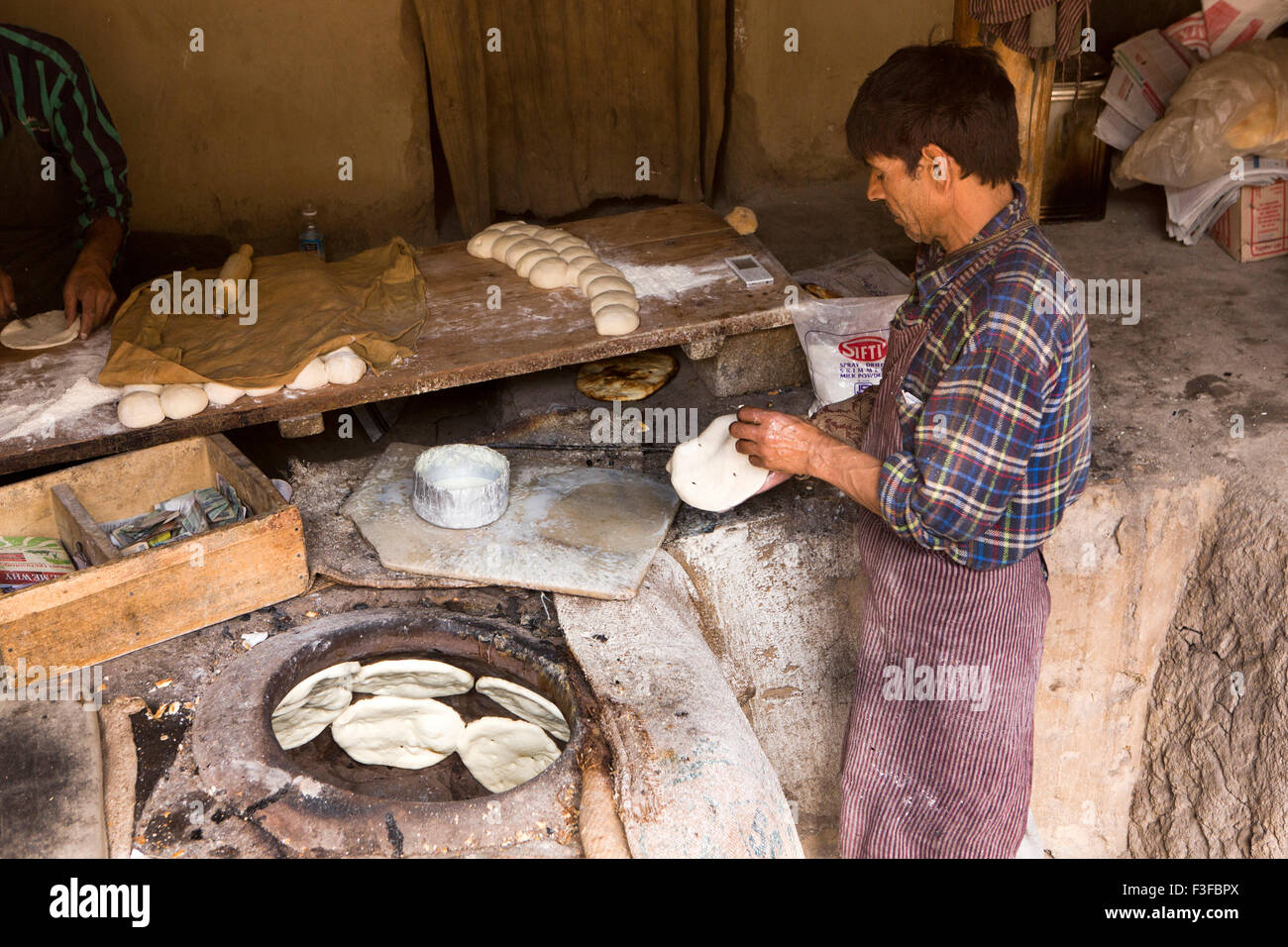 L'Inde, le Jammu-et-Cachemire, Ladakh, Leh, Chutauyrangtak Baker Street, la préparation du pain à cuire dans ladakhis four tandoor Banque D'Images