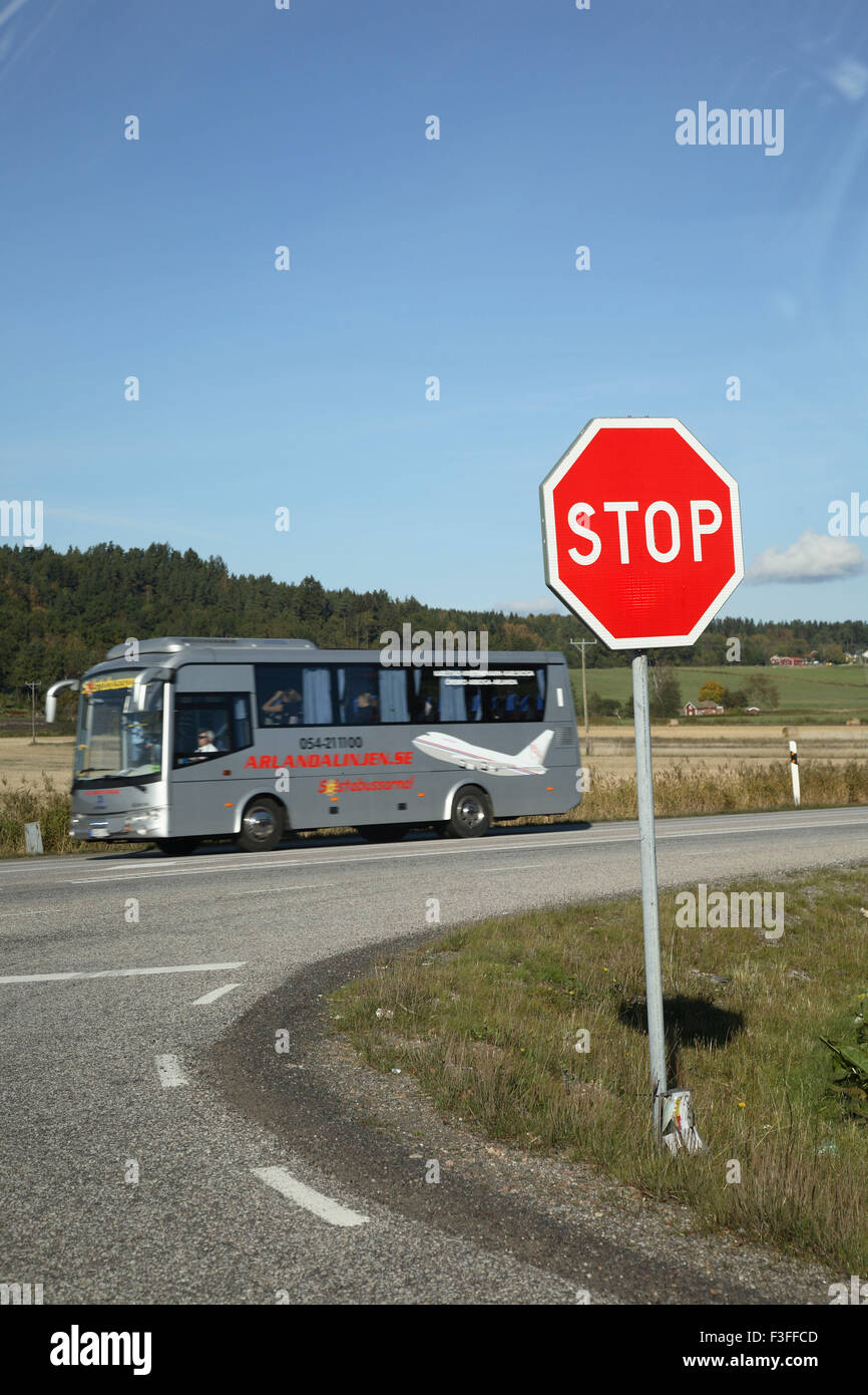 Panneau blanc et rouge montrant arrêter en caractères gras et bus en arrière-plan ; la Suède Banque D'Images