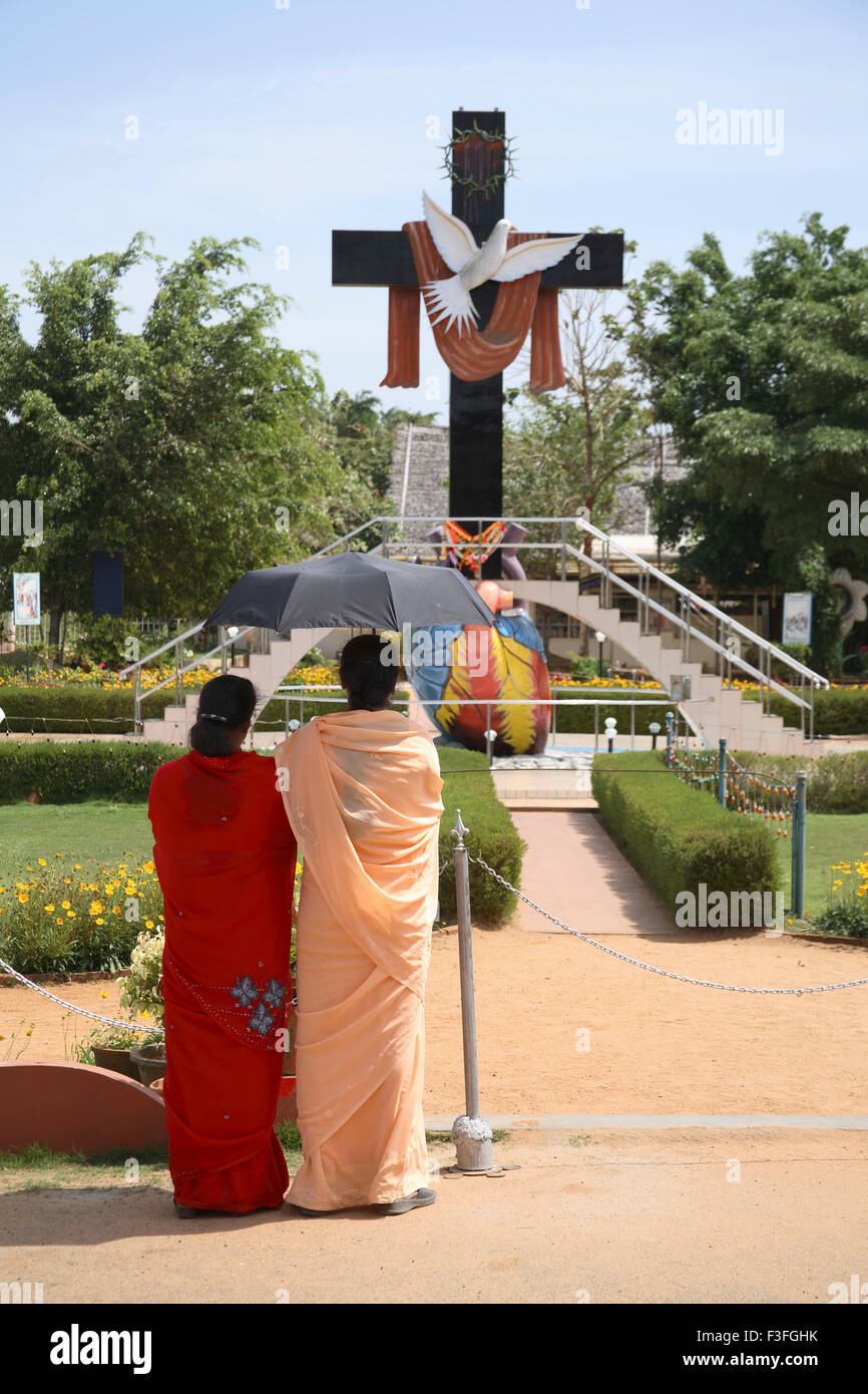 Deux dames holding umbrella standing Cross symbole de l'Esprit Saint et hart sacré à Jérusalem Parc spirituel Kerala Thalore Banque D'Images
