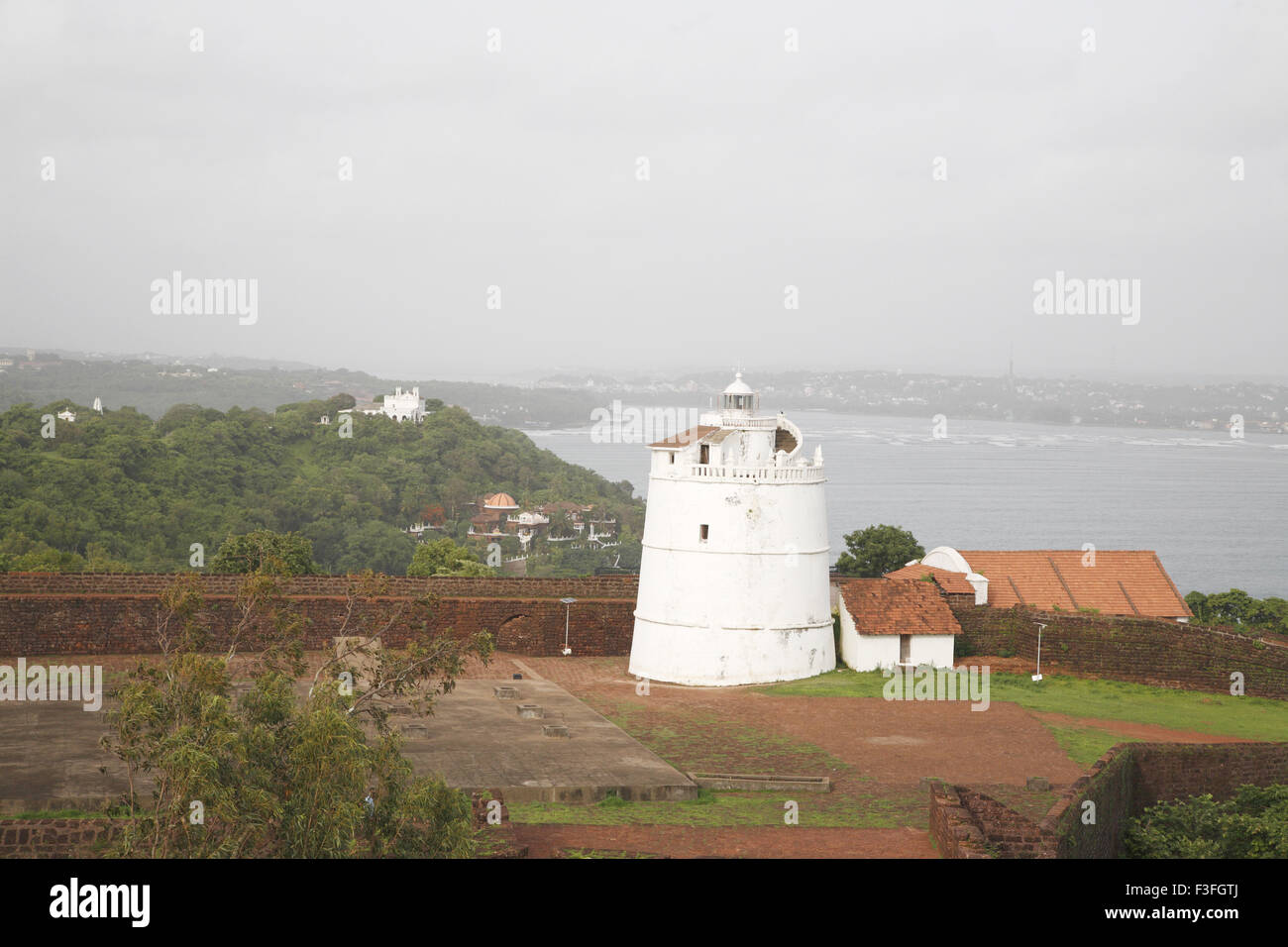 Light House sur le dix-septième siècle d'Aguada fort portugais plage de Sinquerim en arrière-plan ; Goa Inde ; Banque D'Images