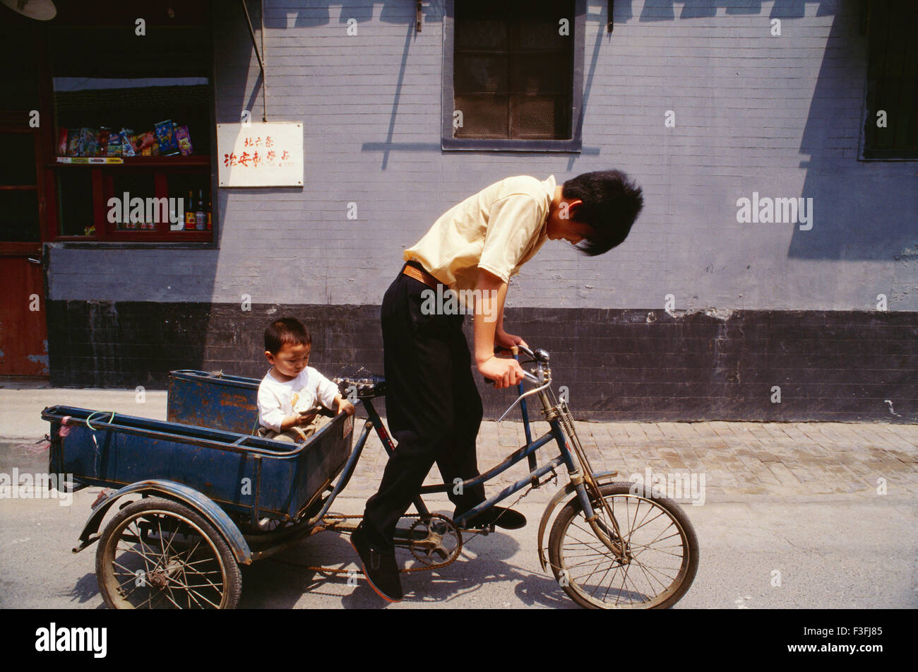 Père prend son enfant sur un tricycle ; Chine Banque D'Images