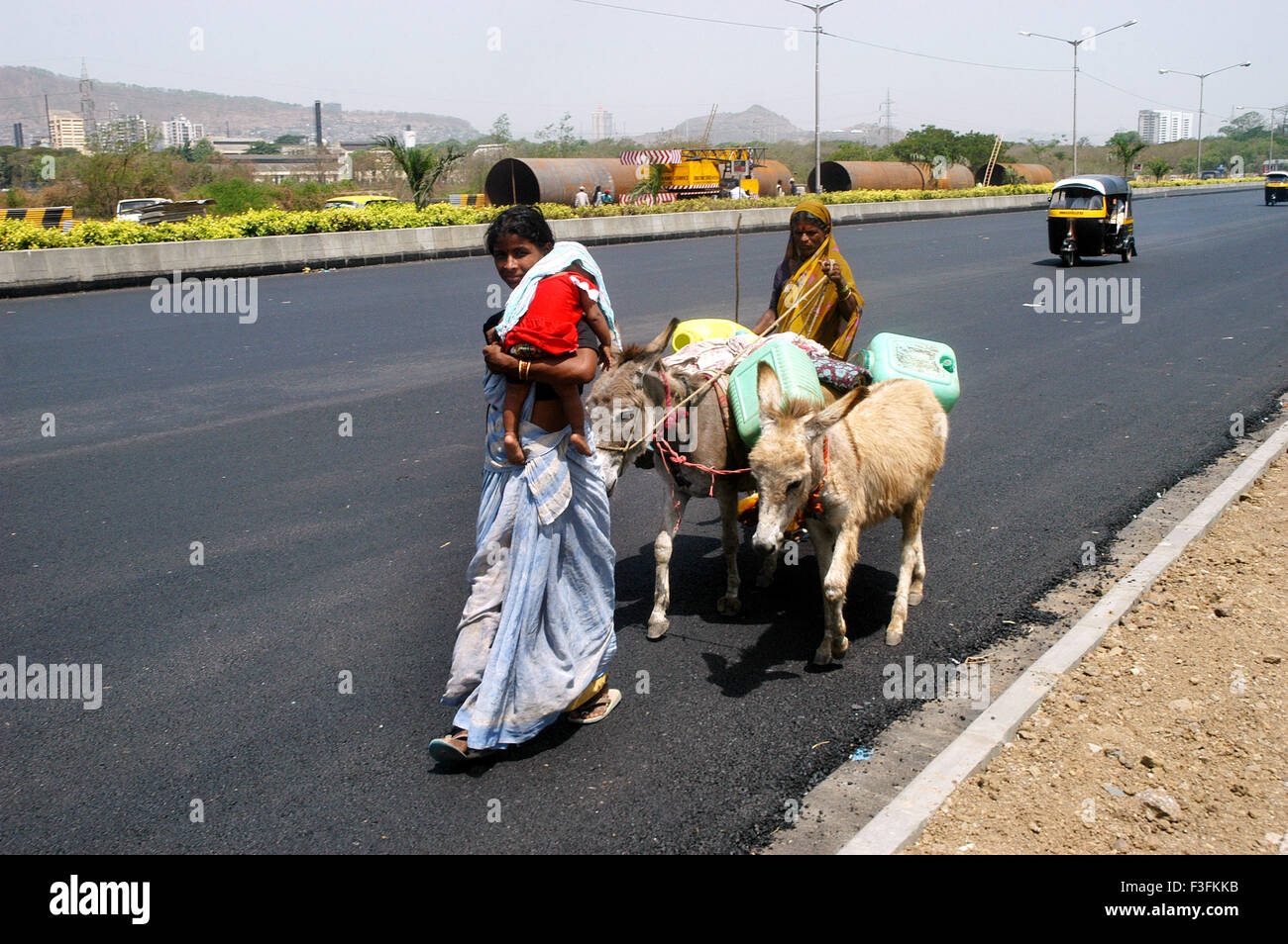 Deux femmes marchant avec les ânes utilisés pour le transport des débris dans Bombay Mumbai Maharashtra ; Inde ; Banque D'Images