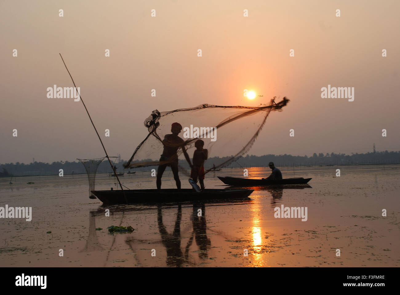 Les pêcheurs de voile net jeter en silhouette Banque D'Images