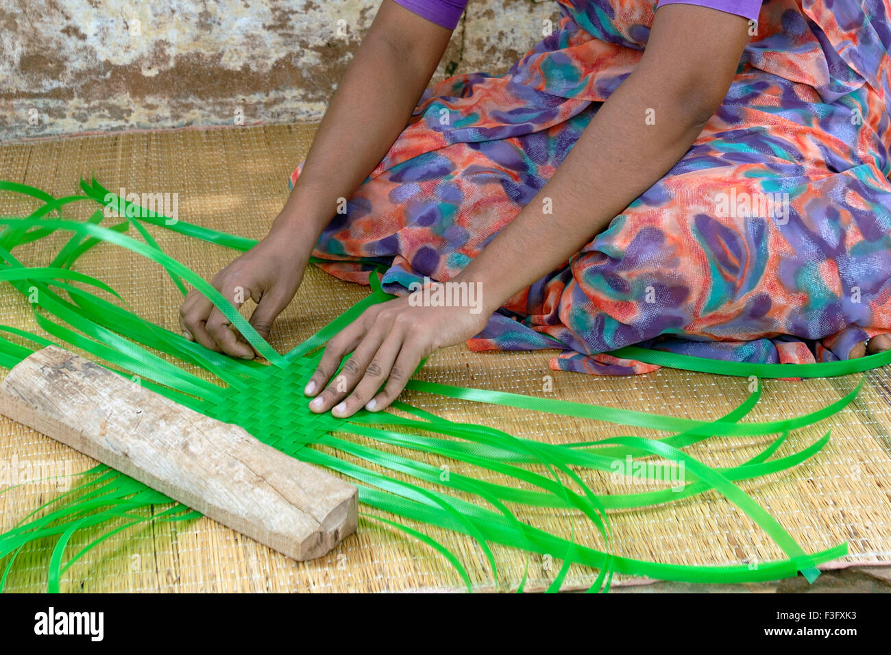 L'industrie familiale ; Femme tissant des bandes en plastique ; paniers ; Tamil Nadu Inde Banque D'Images