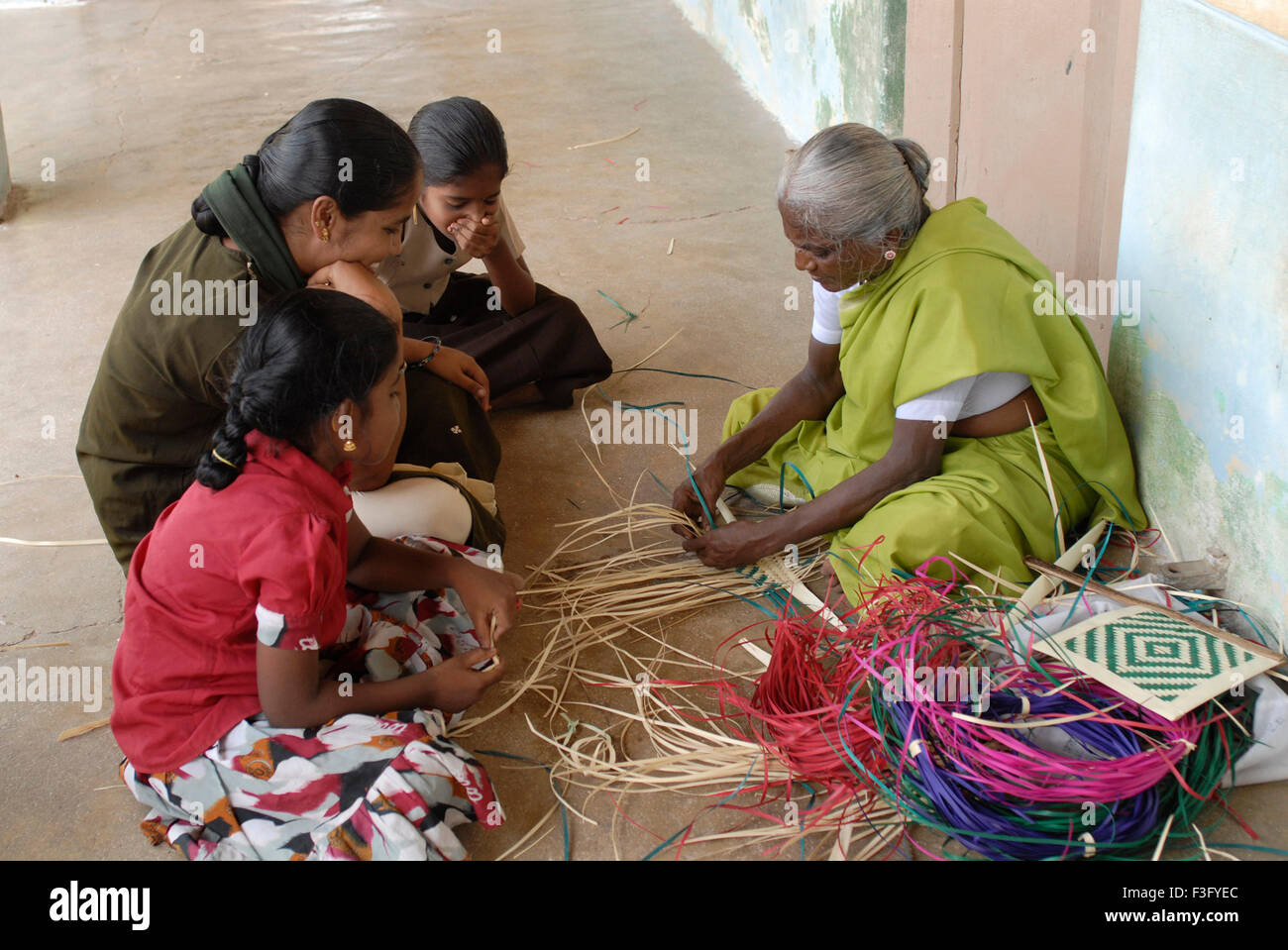 Vieille Femme tissant avec les feuilles de palmier à Manappad ; Tamil Nadu Inde ; Banque D'Images
