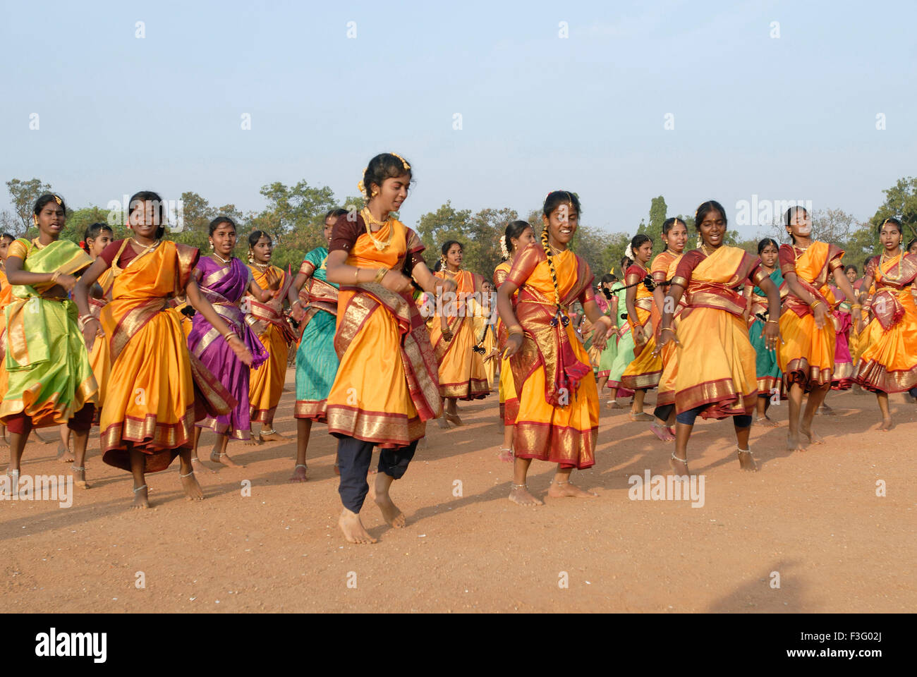 Les femmes qui exécutent la danse indienne traditionnelle sur le sol pour une occasion spéciale ; Inde Banque D'Images