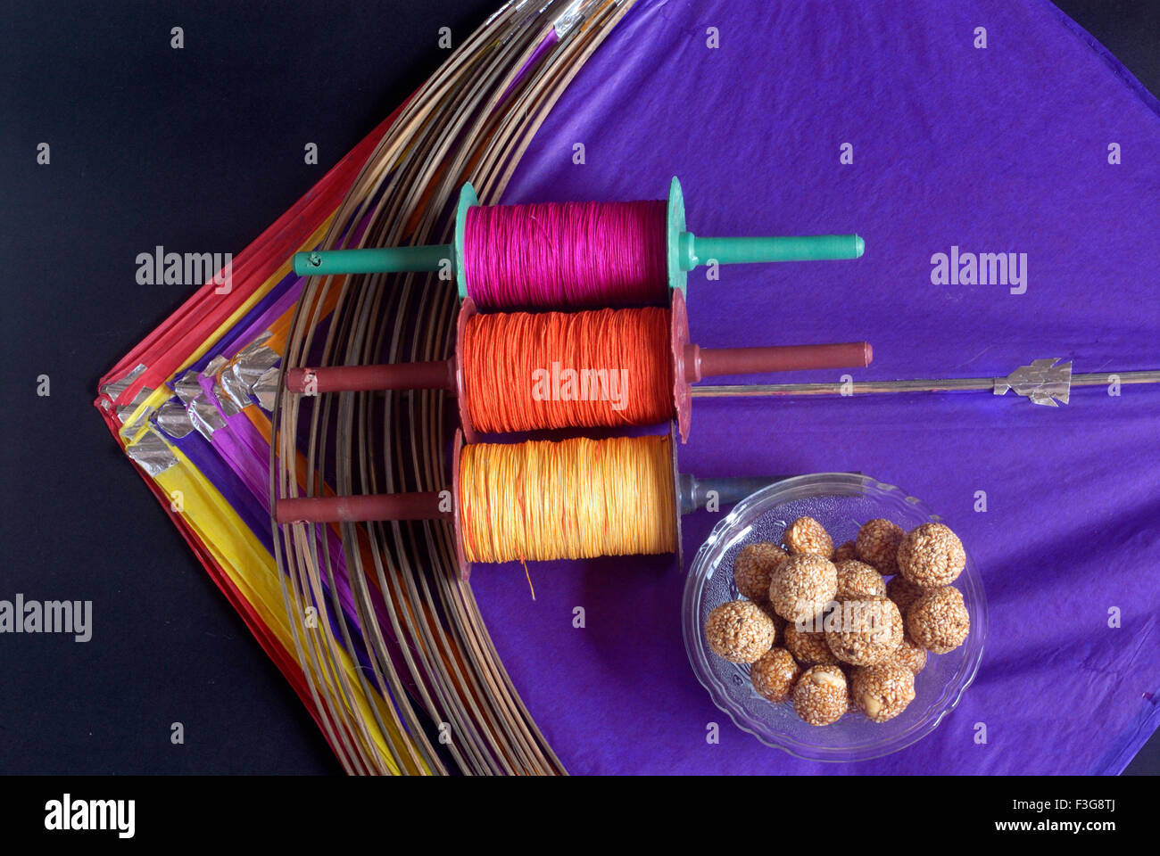 Kites ; bobines de manja colorés ; chikki ladoos de sésame pour célébrer Makara Sankranti Festival Mumbai Banque D'Images