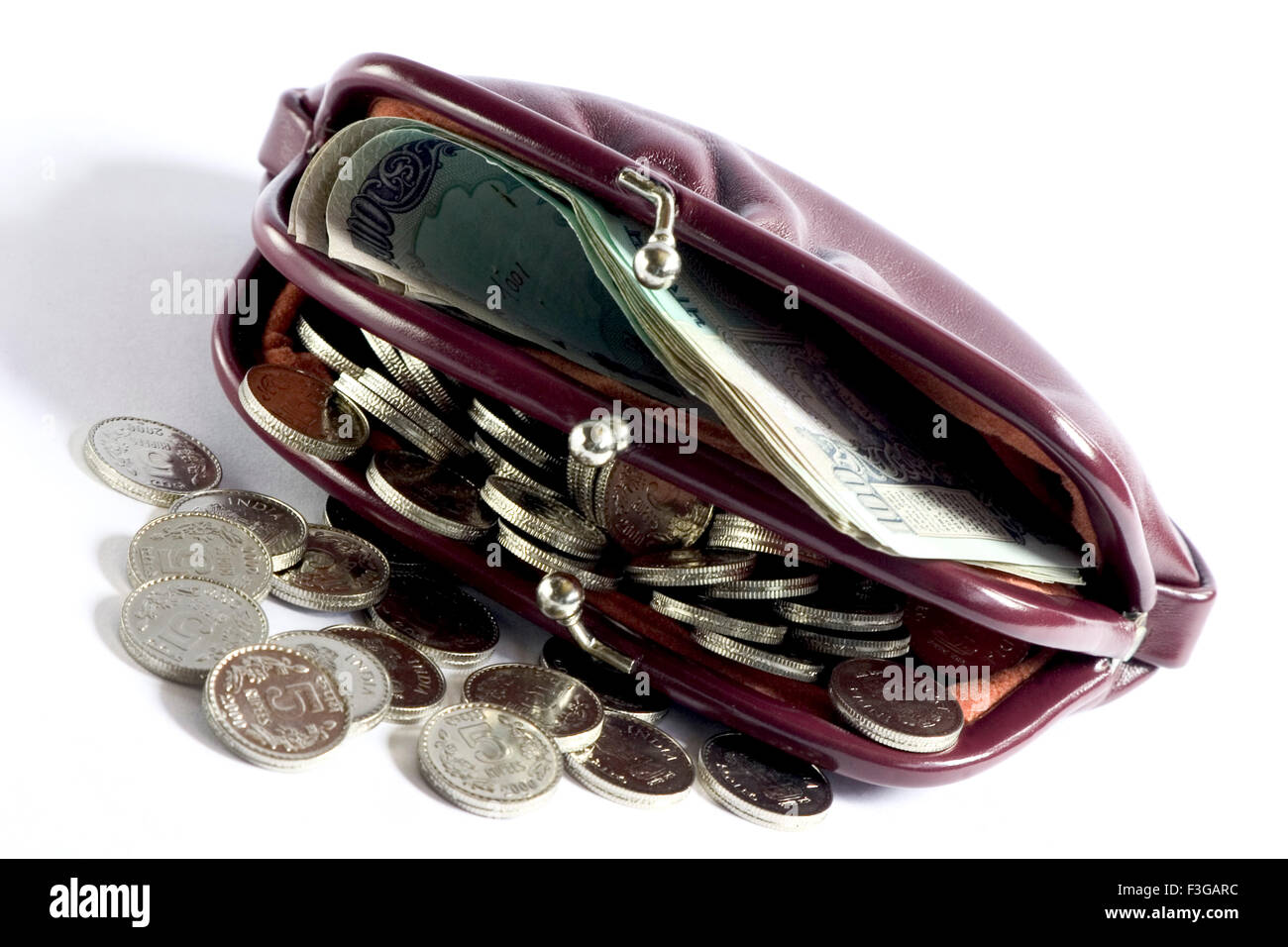 Un déverrouiller mesdames sac à main ou portefeuille exposé beaucoup de monnaie indienne cent roupies et 5 roupies pièce sur fond blanc Banque D'Images