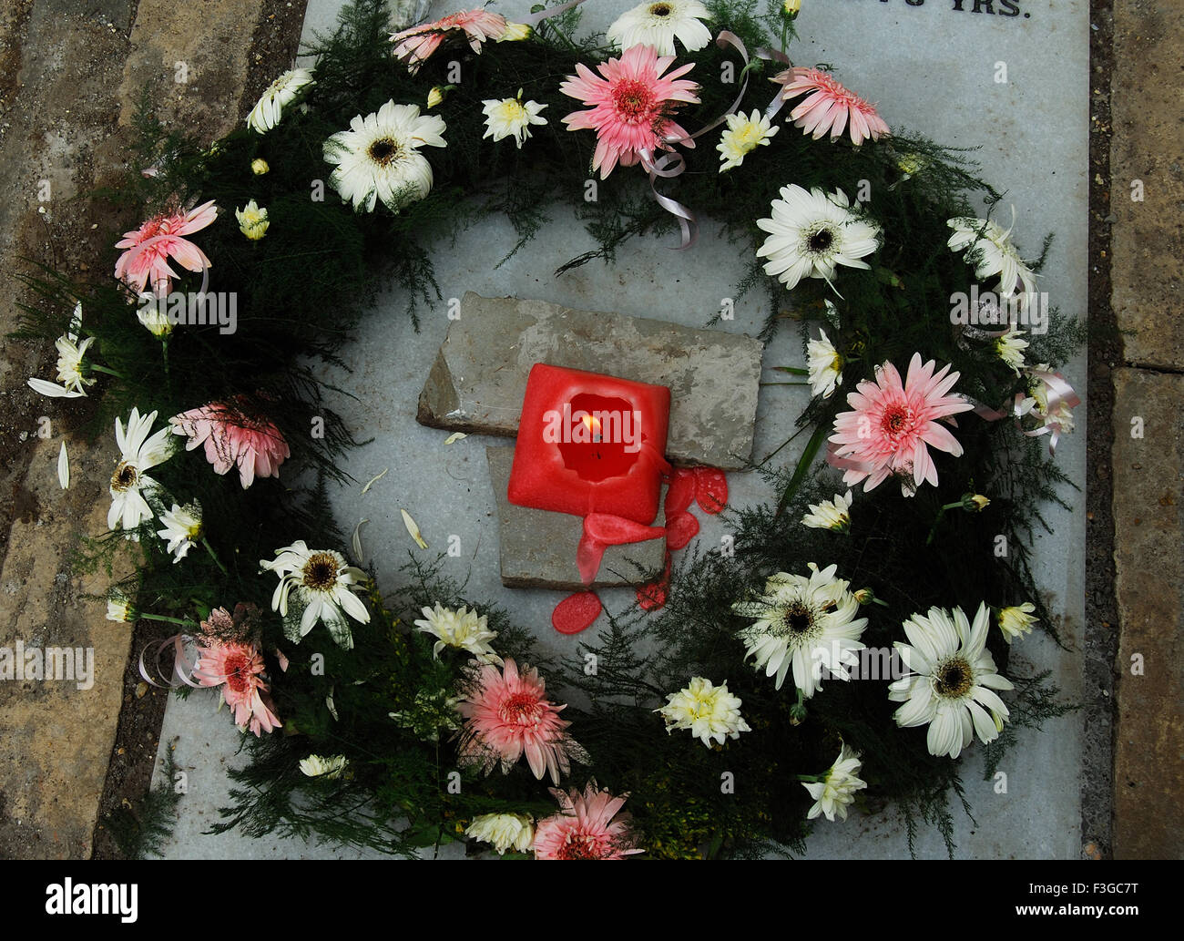 Floral et bougie sur une fosse pour rendre hommage à l'âme a quitté le 2ème jour de son enterrement Banque D'Images