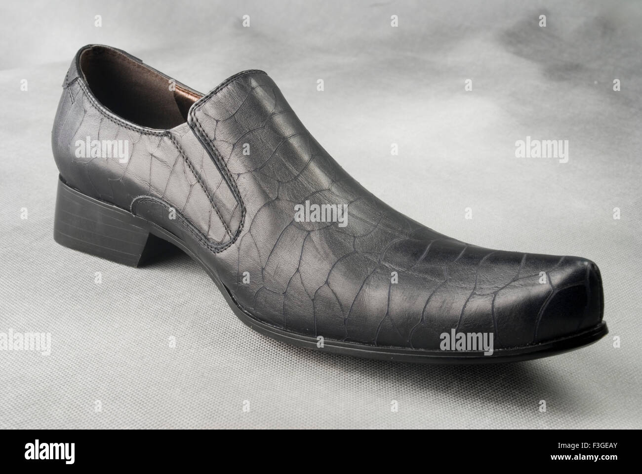 Chaussure en cuir noir sur fond gris MR Banque D'Images