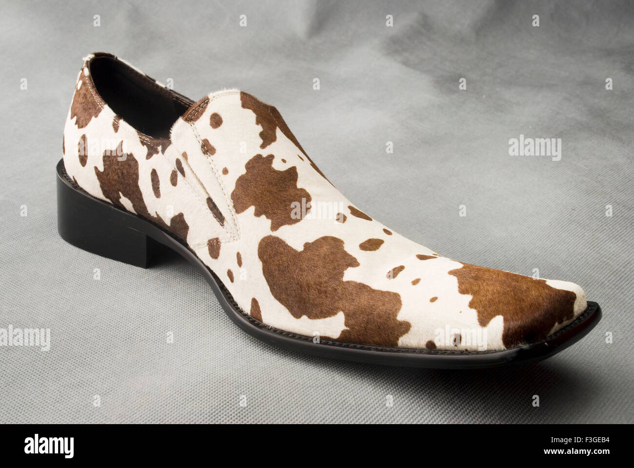 Chaussure en cuir de couleur de la peau avec des taches sur fond gris MR Banque D'Images