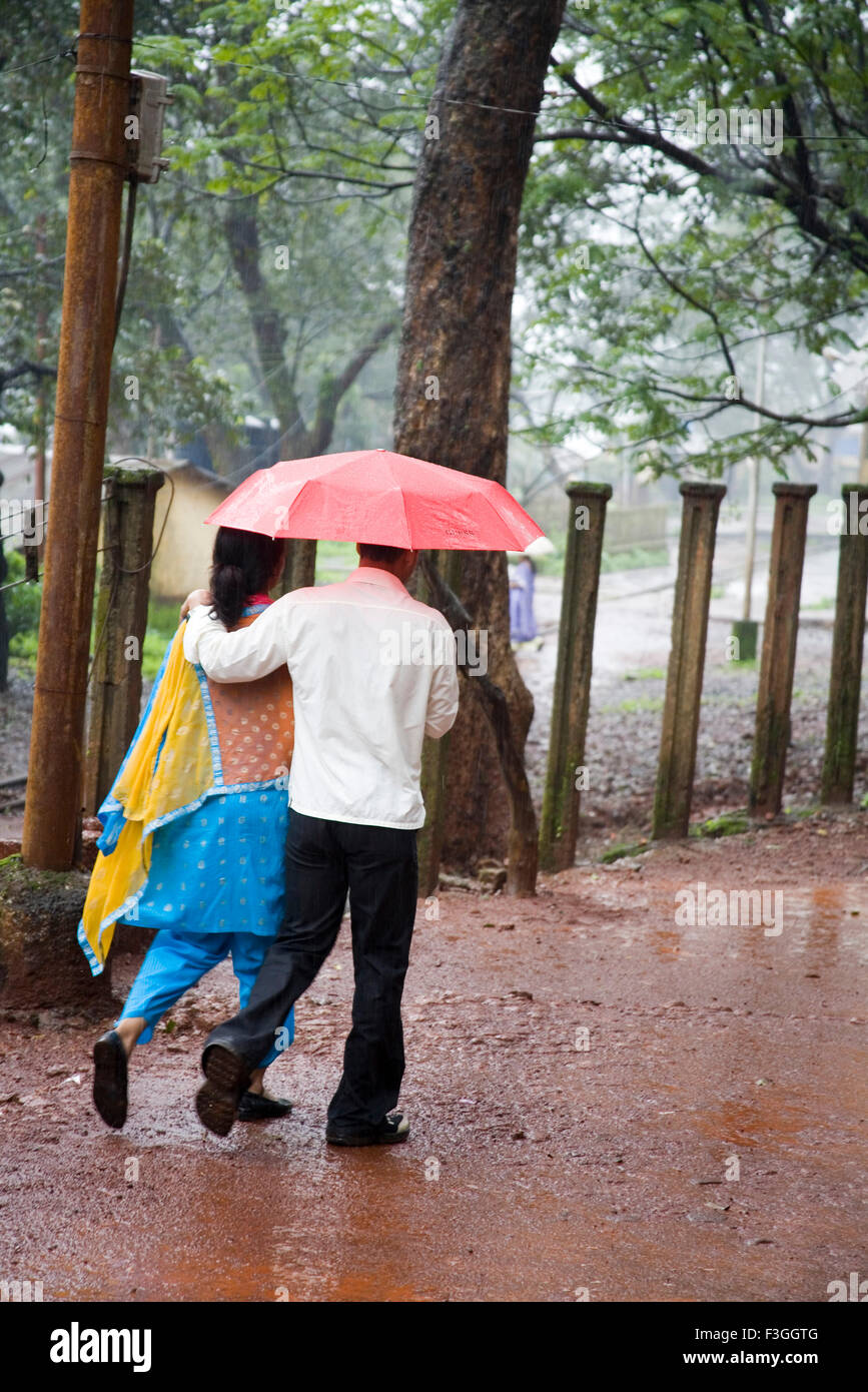 Couple en train de marcher sur la pluie de mousson ; ; ; ; Inde Maharashtra Matheran Banque D'Images