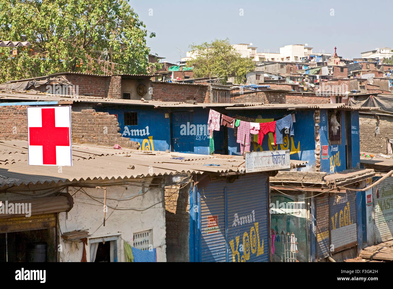 Panneau bien visible de la clinique du médecin sur le toit haut de pauvres des bidonvilles et les conditions d'hygiène de vie entraîner diverses maladies Mumbai Banque D'Images