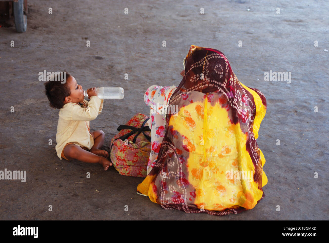 Étancher la soif d'un enfant à la plate-forme ferroviaire ; Inde Rajasthan ; Banque D'Images