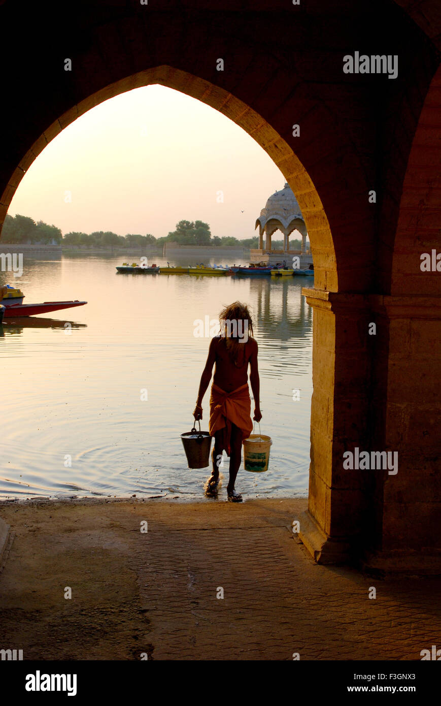 Vieil homme portant de l'eau de Gadisar ; ; ; Inde Rajasthan Jaisalmer Banque D'Images
