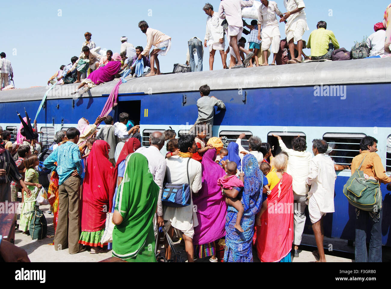 Les gens en faisant glisser les enfants et les femmes qui essaient de grimper sur le toit de la gare de train à jodhpur rajasthan ; ; ; l'Inde - shi 141783 Banque D'Images