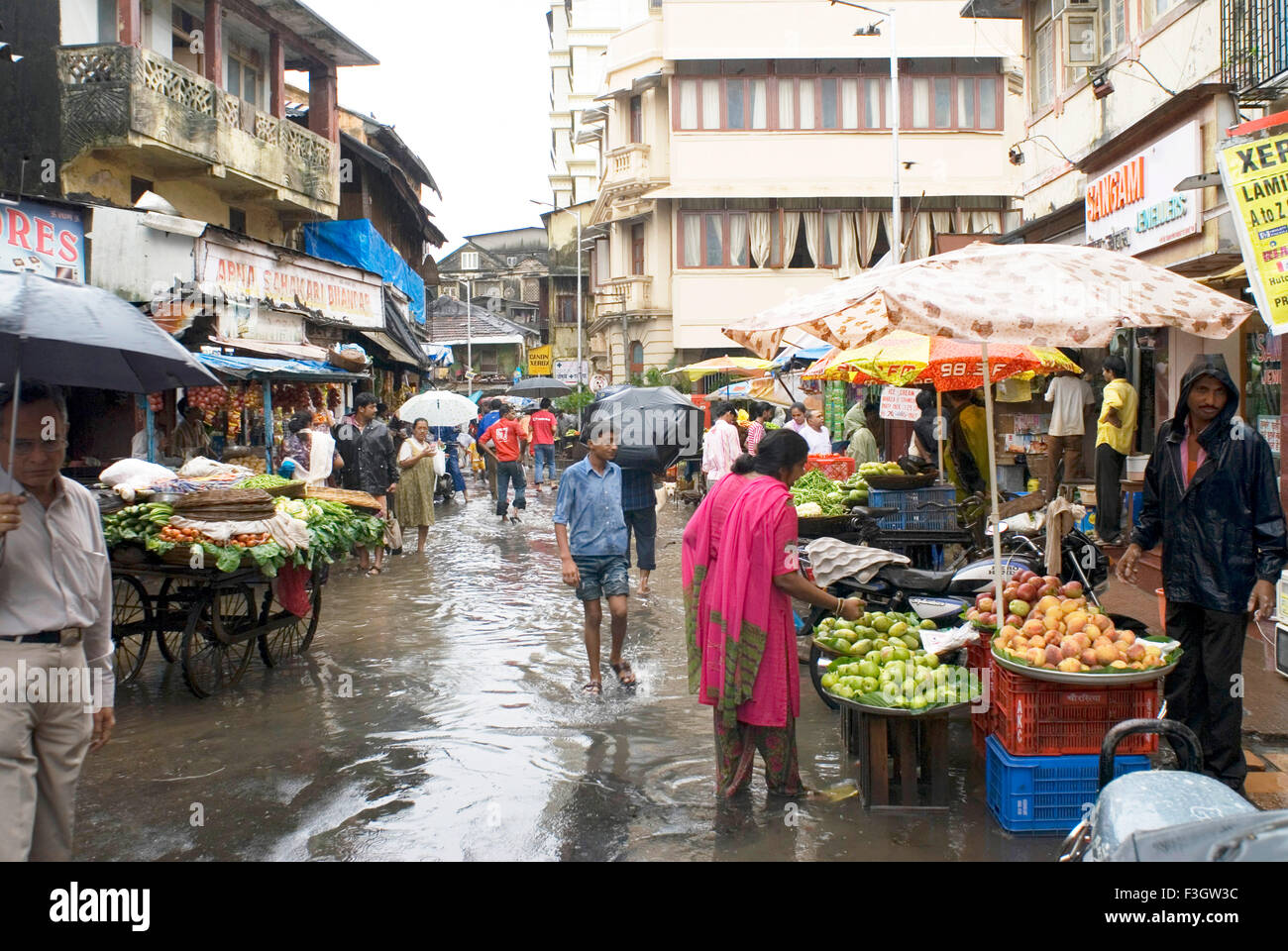 La forte pluie et les gens dans les magasins de marketing sur la route inondée à Bandra Lane ; Bombay Mumbai Maharashtra ; Inde ; Banque D'Images