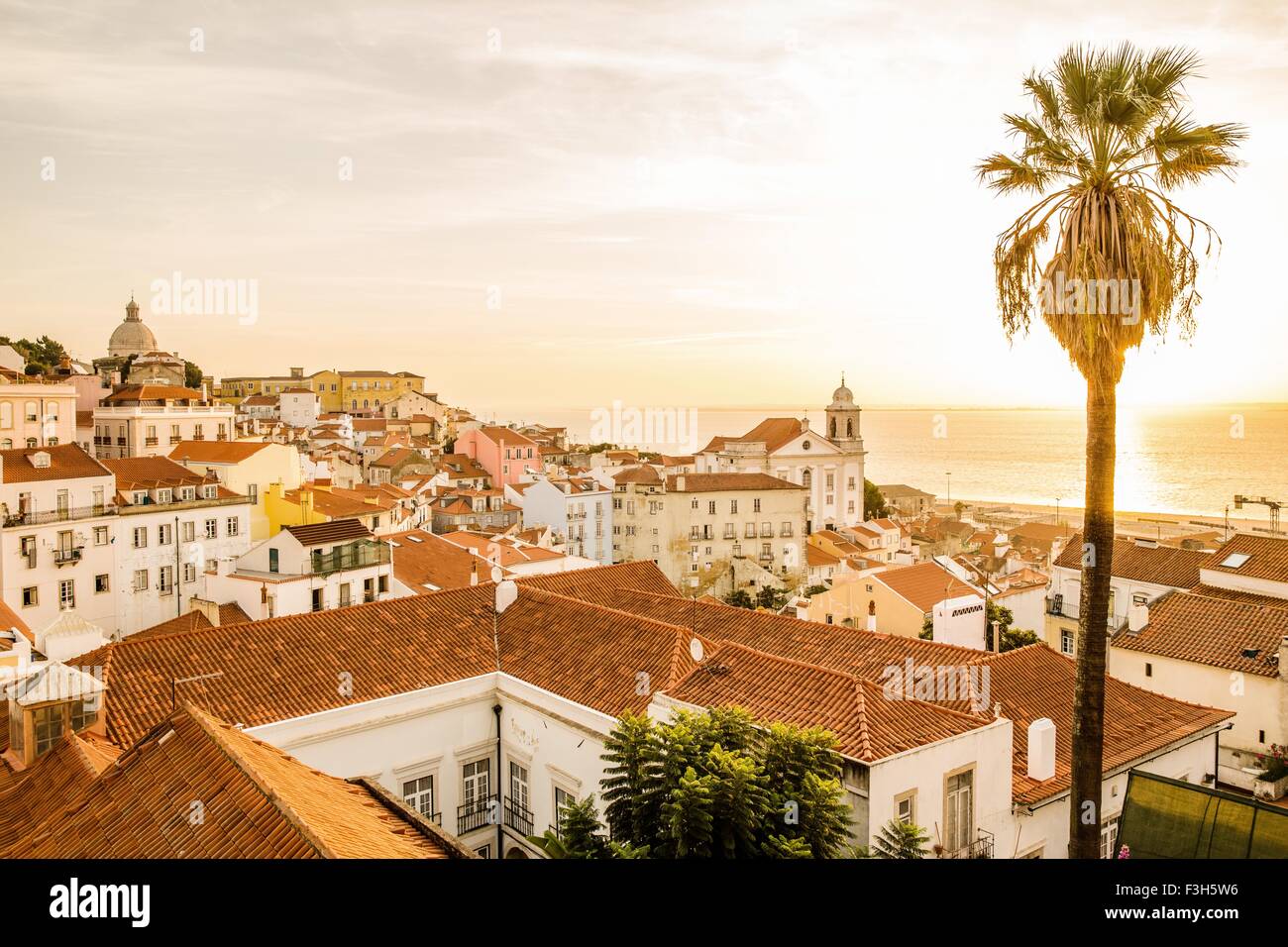 Vue sur les toits en terre cuite de Lisbonne, Portugal alors que le soleil se couche sur l'océan Banque D'Images