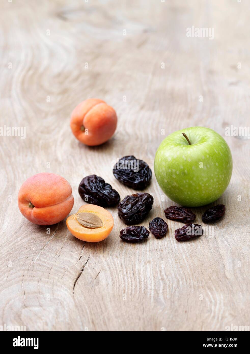Pomme verte, les abricots et les pruneaux sur table en bois Banque D'Images